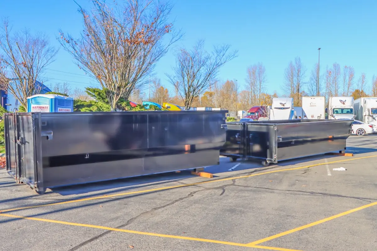 Professional dumpster rental service with roll-off container on residential driveway in Sudley